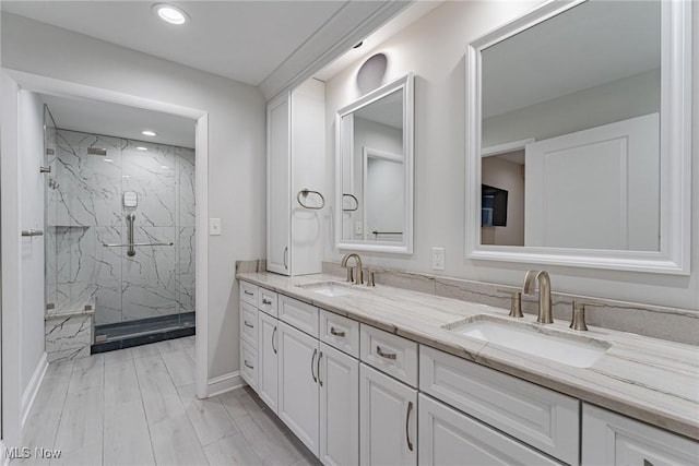 bathroom featuring hardwood / wood-style flooring, vanity, and walk in shower