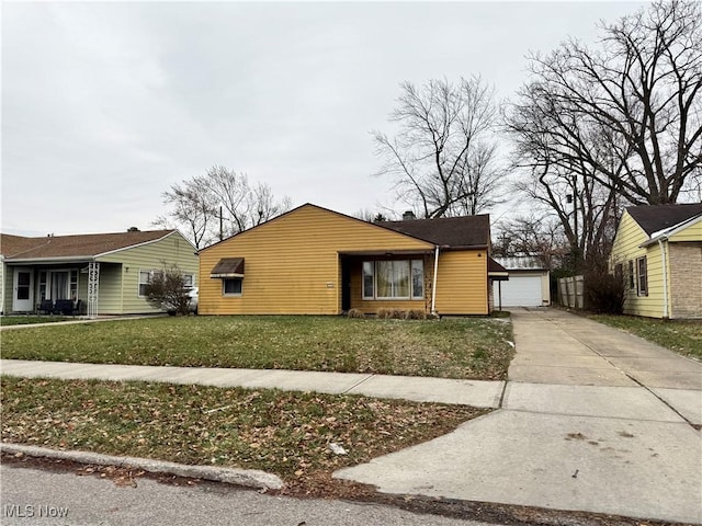 view of front facade featuring an outbuilding, a front yard, and a garage