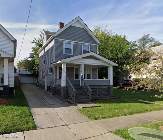 view of front of house with an outbuilding, a porch, a garage, and a front yard