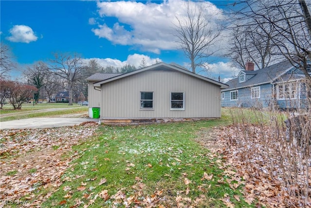 view of side of home with a yard