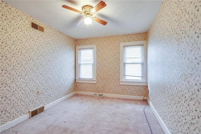 carpeted spare room featuring ceiling fan