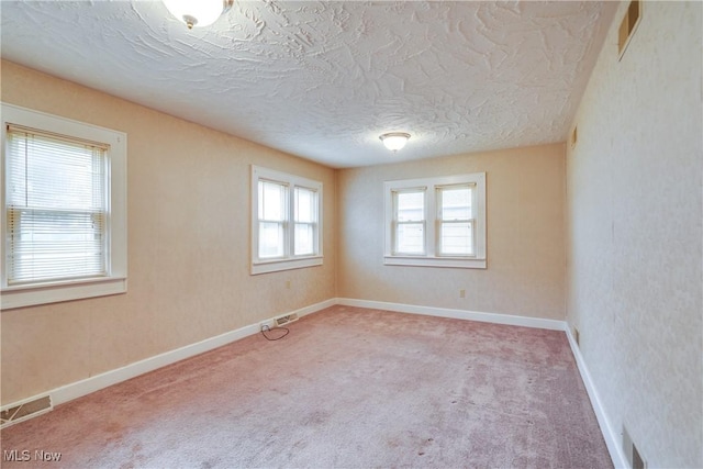 empty room featuring a textured ceiling and carpet floors