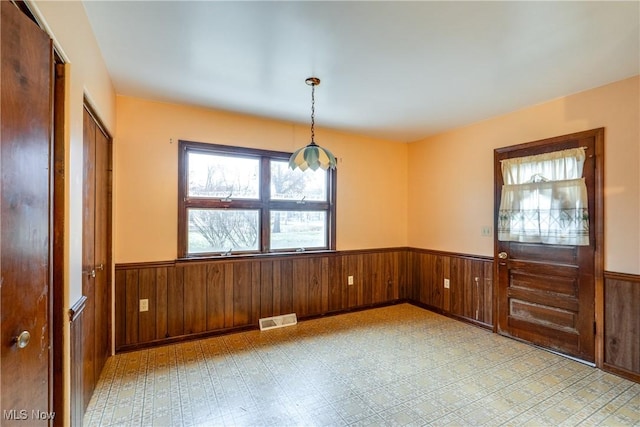 unfurnished dining area with wood walls