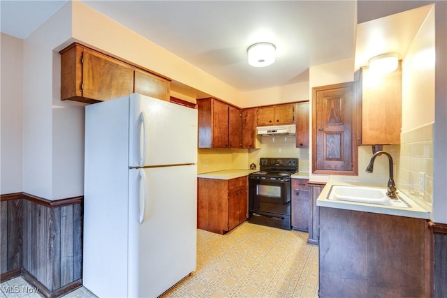 kitchen with electric range, decorative backsplash, white fridge, and sink