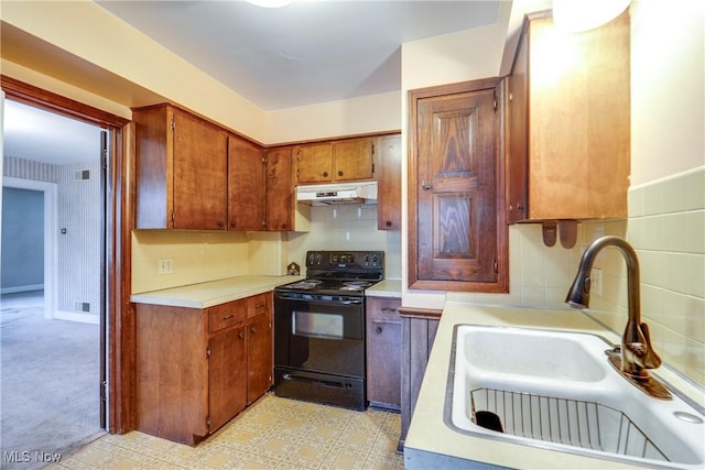 kitchen with decorative backsplash, sink, and black electric range