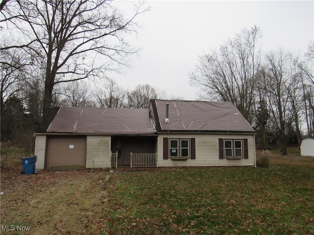 back of house with a lawn and a garage