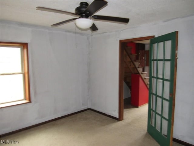 carpeted spare room featuring ceiling fan