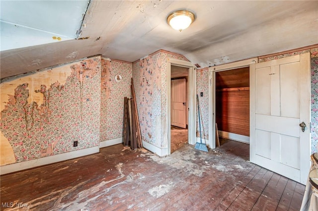 unfurnished bedroom with a closet, dark wood-type flooring, and lofted ceiling