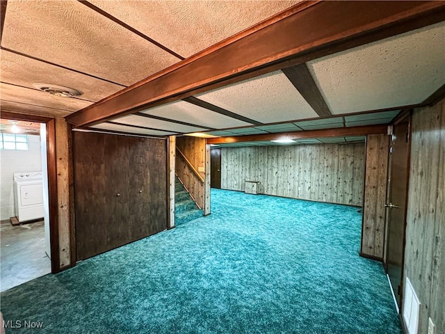 basement with wooden walls, carpet floors, and washer / clothes dryer