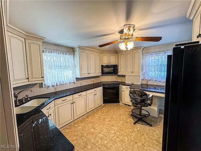 kitchen featuring dark stone counters, ceiling fan, sink, black appliances, and cream cabinets