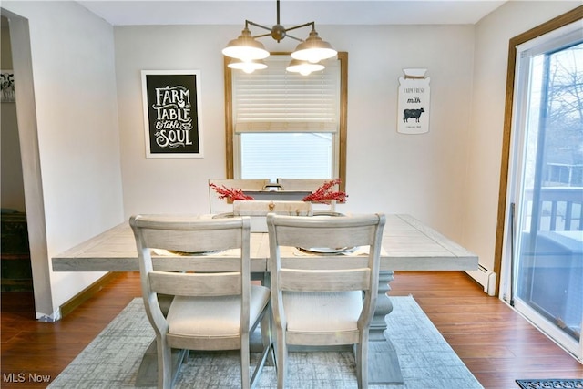 dining area with a baseboard radiator, dark hardwood / wood-style floors, and a notable chandelier