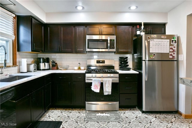 kitchen featuring dark brown cabinets, backsplash, stainless steel appliances, and sink