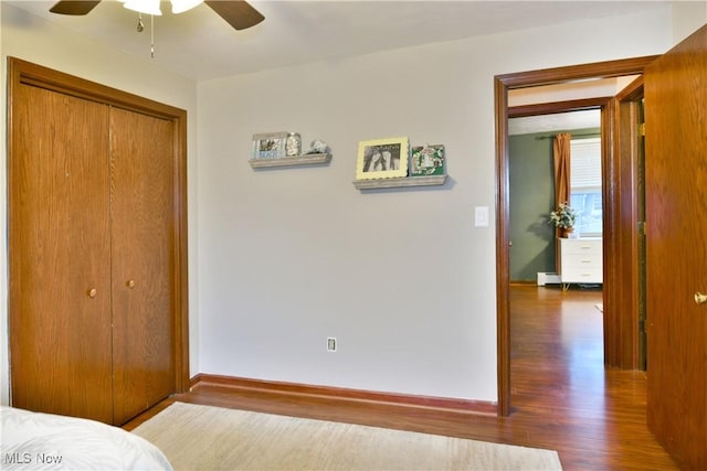 bedroom with a closet, dark wood-type flooring, and ceiling fan