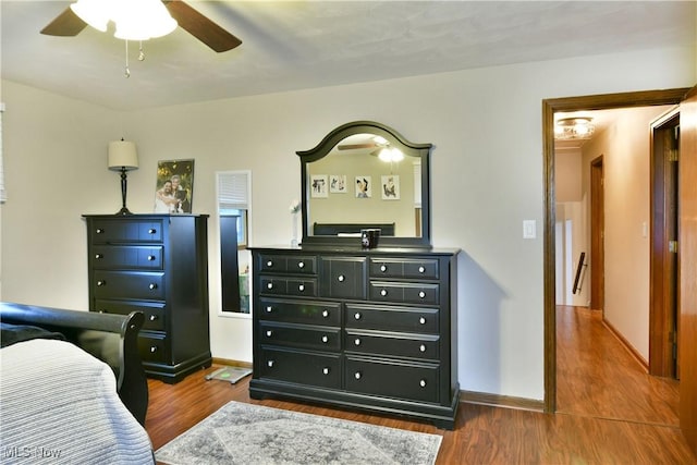 bedroom with dark hardwood / wood-style flooring and ceiling fan