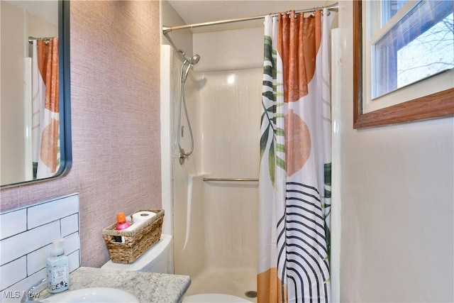 bathroom featuring a shower with curtain, sink, and toilet