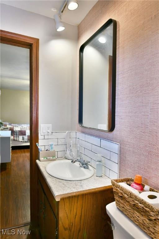 bathroom featuring hardwood / wood-style flooring, vanity, and toilet