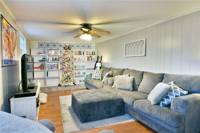 living room featuring ceiling fan, crown molding, and light wood-type flooring