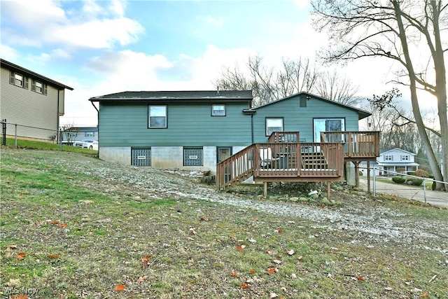 back of property with a lawn and a wooden deck