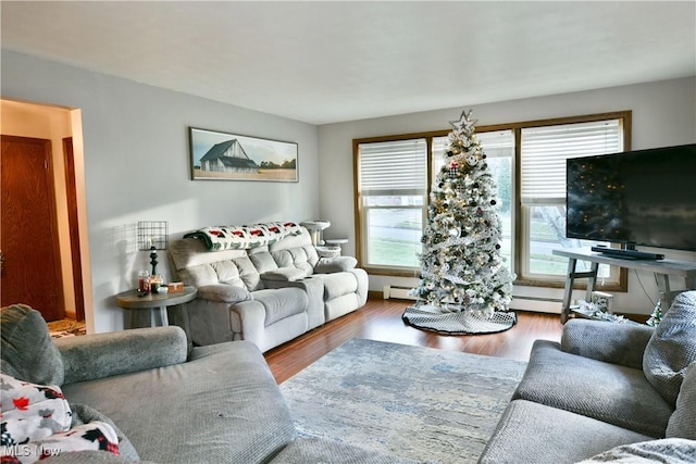 living room with baseboard heating, hardwood / wood-style floors, and a healthy amount of sunlight