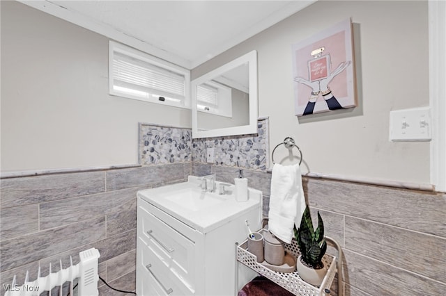 bathroom featuring vanity, radiator, and tile walls