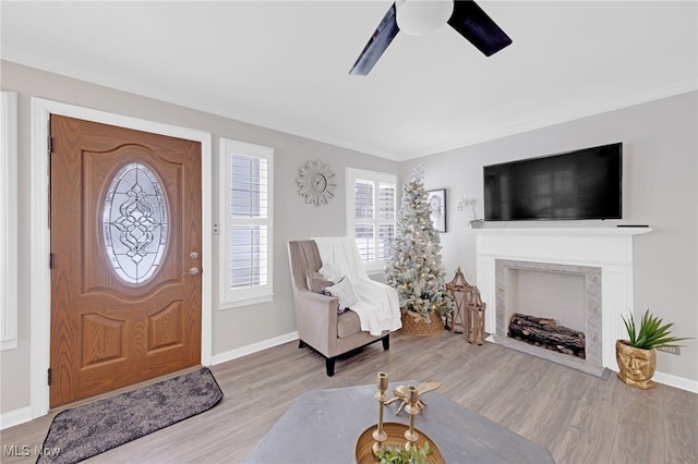 entrance foyer featuring light hardwood / wood-style flooring, ceiling fan, and ornamental molding