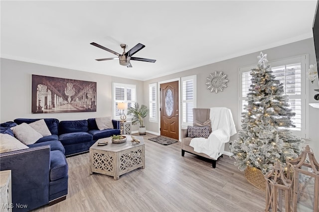 living room featuring crown molding, light hardwood / wood-style flooring, and a healthy amount of sunlight