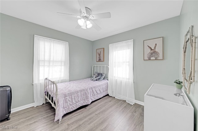 bedroom with light hardwood / wood-style flooring, multiple windows, and ceiling fan