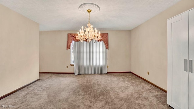 empty room featuring a textured ceiling, light carpet, and an inviting chandelier