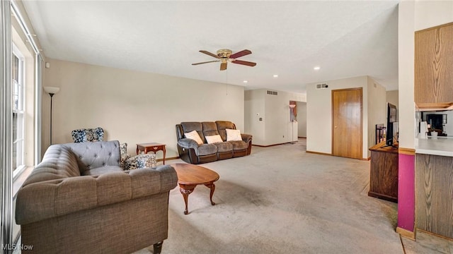 carpeted living room with ceiling fan