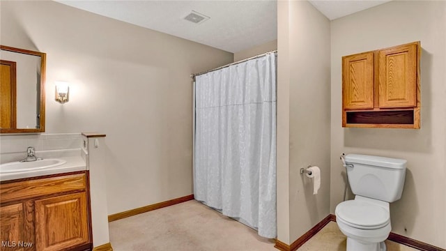 bathroom featuring vanity, toilet, a textured ceiling, and walk in shower