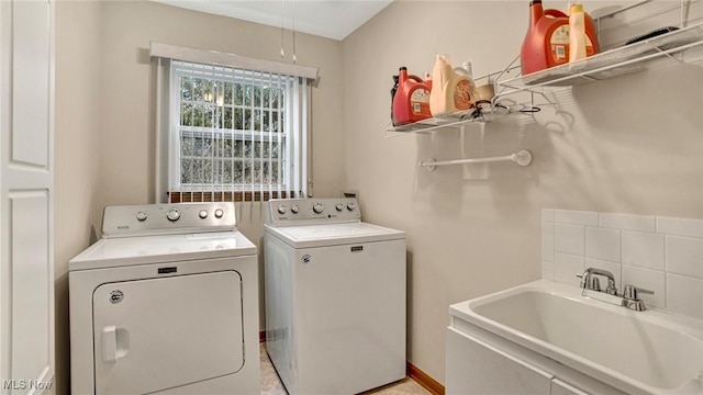 laundry room featuring washing machine and clothes dryer and sink