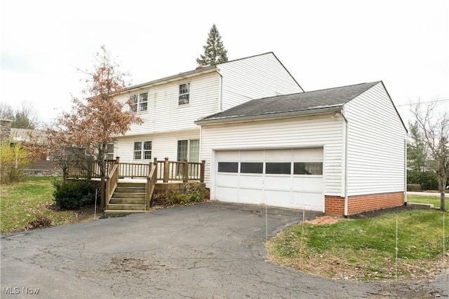 view of front of home with a front lawn, a garage, and a deck