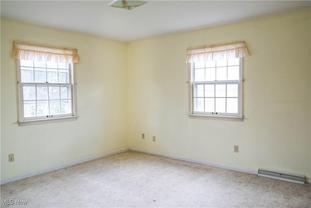 spare room featuring plenty of natural light and light colored carpet