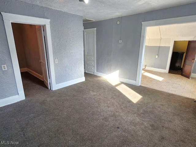 spare room with a textured ceiling and light carpet