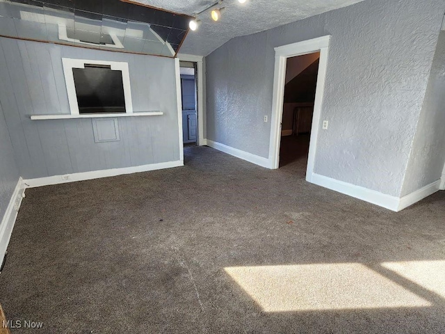 carpeted empty room featuring a textured ceiling