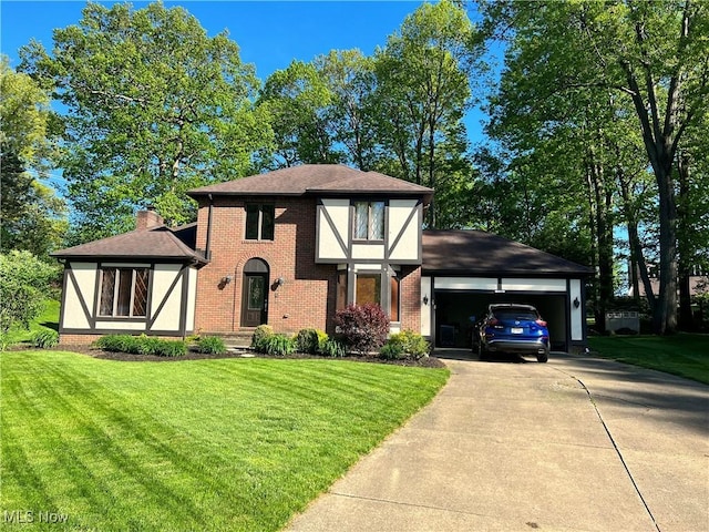 tudor house featuring a front yard and a garage