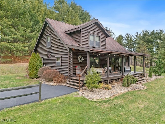 log-style house featuring covered porch and a front lawn