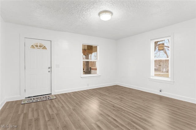 foyer with hardwood / wood-style flooring and a textured ceiling