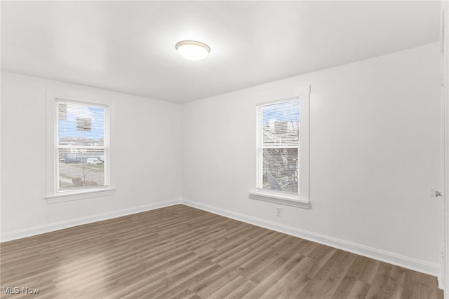 spare room with hardwood / wood-style flooring and a healthy amount of sunlight