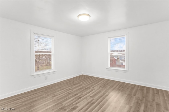 spare room with plenty of natural light and wood-type flooring