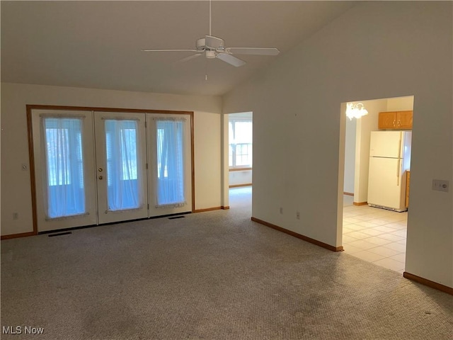 carpeted spare room featuring ceiling fan, french doors, and lofted ceiling