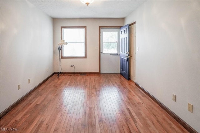 spare room featuring wood-type flooring and a textured ceiling