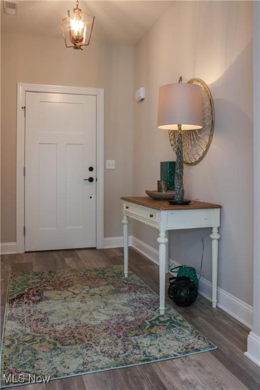 foyer featuring a notable chandelier and dark wood-type flooring