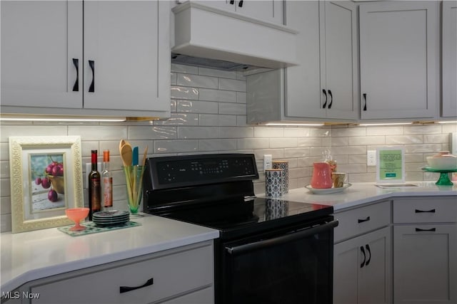 kitchen featuring white cabinetry, decorative backsplash, and black electric range oven