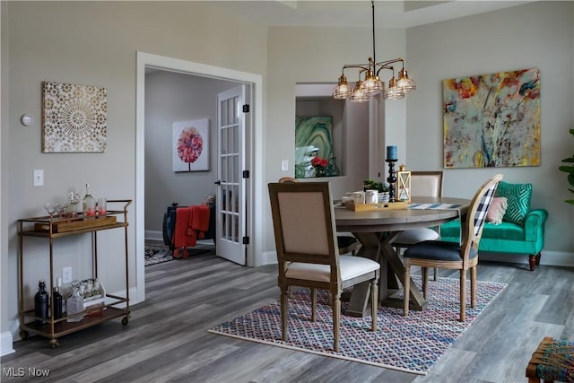 dining room featuring dark hardwood / wood-style floors and an inviting chandelier