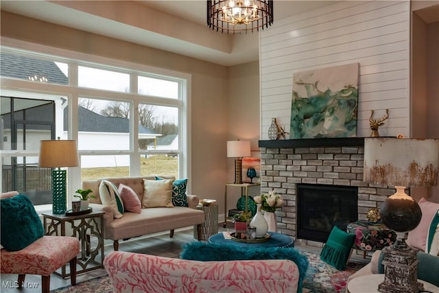 living room featuring a brick fireplace and a notable chandelier