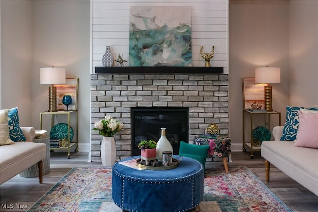 sitting room with a fireplace and dark wood-type flooring