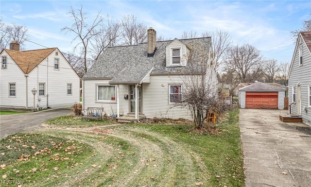 new england style home featuring an outbuilding, a front yard, and a garage