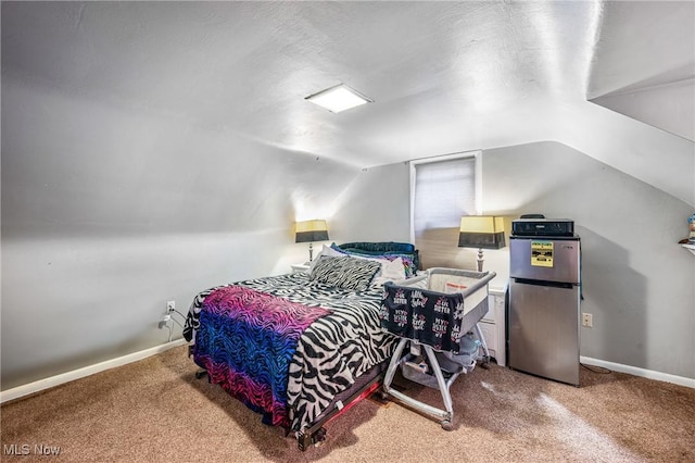 bedroom featuring carpet, vaulted ceiling, and stainless steel refrigerator