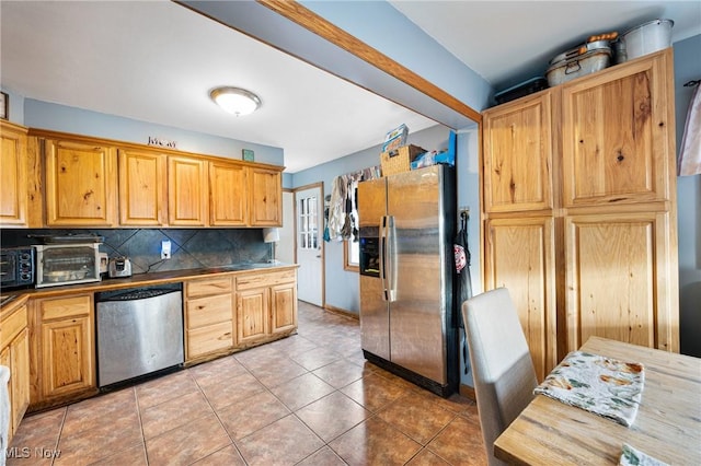 kitchen with backsplash, light tile patterned flooring, and stainless steel appliances